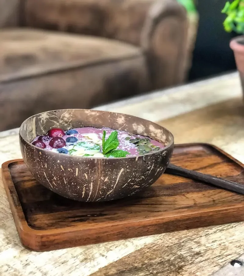 Bowl de açaí en cáscara de coco con fruta y menta