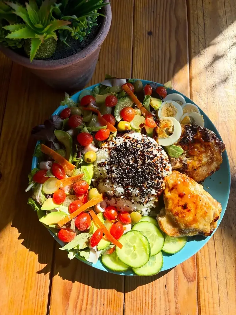 Plato con ensalada, tomate, pepino, huevo y pollo