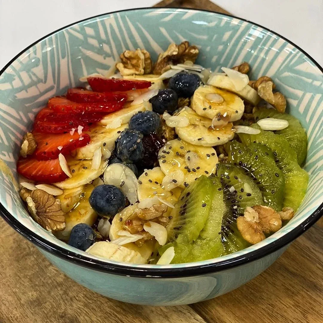 Bowl de yogur con fresas, arándanos, plátano, kiwi y nueces