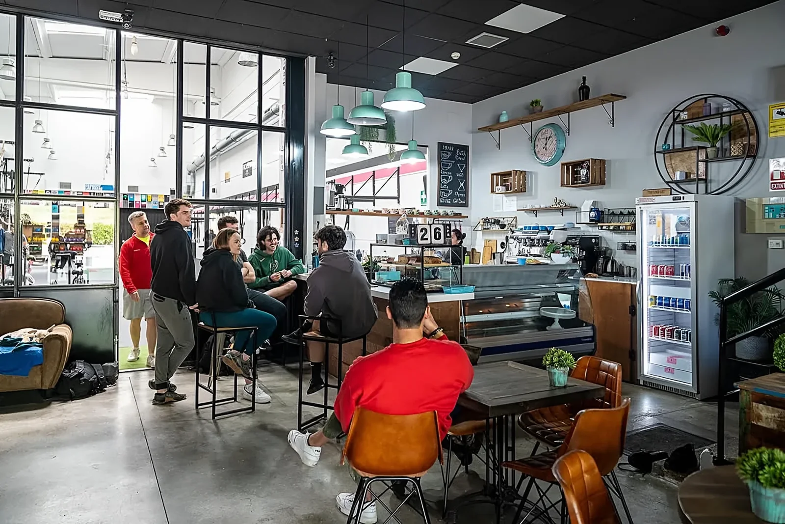 La barra de La Calma por la mañana, con lámparas menta y clientes desayunando
